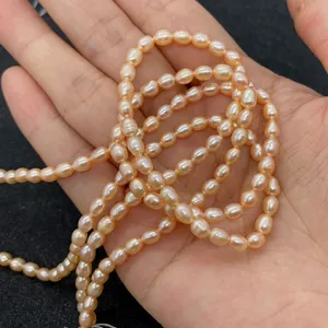 Macro shot of natural oval freshwater pearls in pink on a hand showing natural luster
