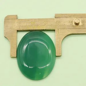 Dettaglio di un cabochon ovale in pietra verde da 30mm misurato con calibro in ottone