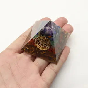 Orgonpyramide mit Amethyst und Chakra-Steinen in der Hand zur energetischen Heilung