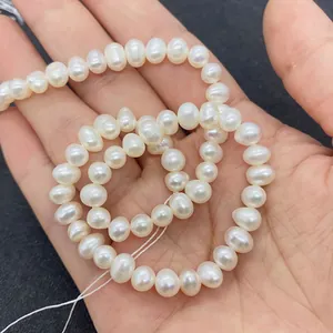 Macro view of white freshwater pearls on a hand showing natural luster and texture