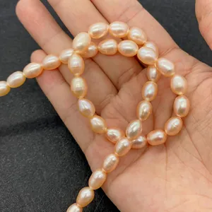 Macro shot of pink oval freshwater pearls being held to show size and natural luster