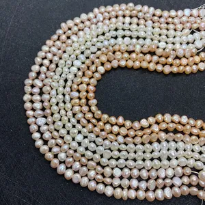 Detailed view of natural freshwater pearls in white, pink, and champagne on black surface