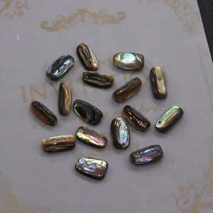 Vista macro di perle di conchiglia abalone cangianti per gioielli fai da te su sfondo