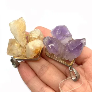 Natuurlijke gele en paarse kristallen cluster hangers in de hand met zilveren sluiting