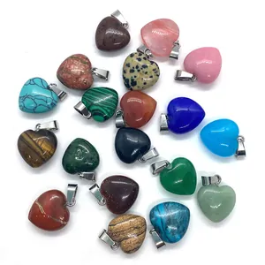 Assorted heart-shaped natural gemstone pendants with silver metal bails on white background