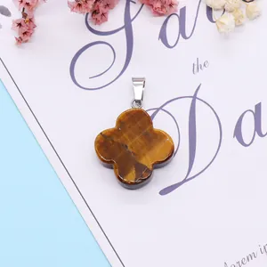 Macro detail of a tiger eye stone clover pendant with a silver metal clasp