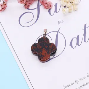 Detail of four-leaf flower stone pendant with red and black texture on white card