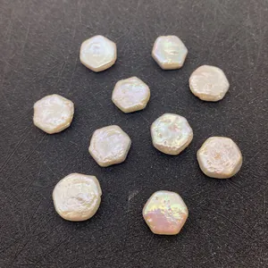 Perles d'eau douce baroques hexagonales plates avec éclat naturel sur fond noir texturé