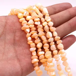 Detalle de cuentas irregulares de concha naranja crema para bisutería DIY