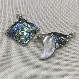 Vue macro de pendentifs géométriques en nacre abalone et blanc avec bélières en argent
