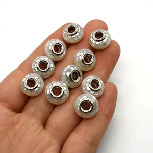 Makroaufnahme von Mosaikperlen aus Naturmuscheln mit großen Löchern für DIY-Schmuck