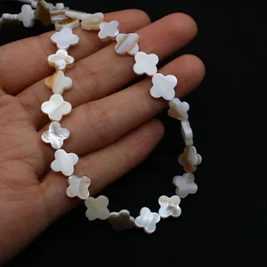 Détail macro de perles en nacre naturelle trèfle à quatre feuilles pour bijoux DIY