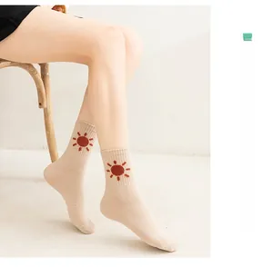 Detail of combed cotton mid-calf socks for women featuring a cute sun embroidery