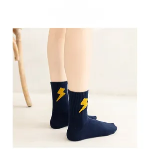 Detailed close-up of a navy blue combed cotton sock featuring a yellow lightning pattern