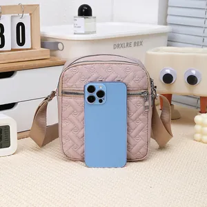 Detail of pink-purple quilted crossbody bag showing size comparison with a smartphone