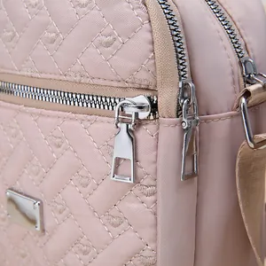 Detailed macro view of quilted pink nylon fabric and silver double zipper hardware