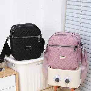 Quilted nylon crossbody bags in black and pink with wide adjustable fabric straps