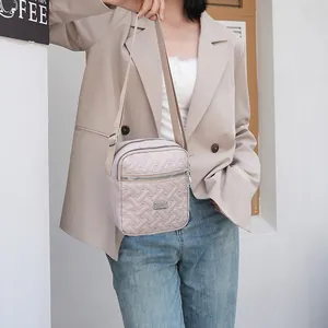 Quilted light pink crossbody bag styled with a beige blazer for a casual daily look