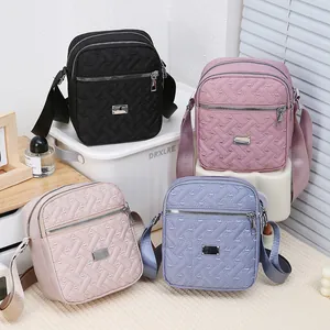 Stylish embroidered nylon crossbody bag in four colors with triple zipper compartments