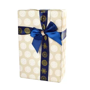 Boîte cadeau beige élégante avec ruban en satin bleu marine et boucle dorée chic