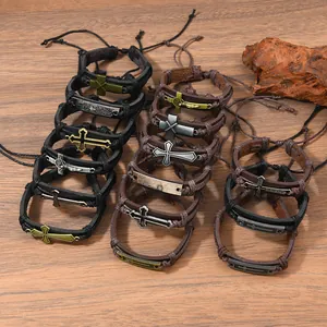 Braided leather bracelets for men with alloy crosses on a rustic wooden texture surface