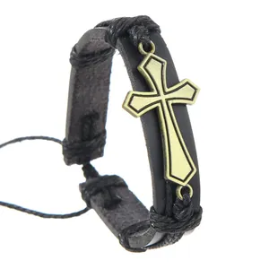 Detail of vintage braided black leather bracelet with bronze cross pendant and adjustable cord