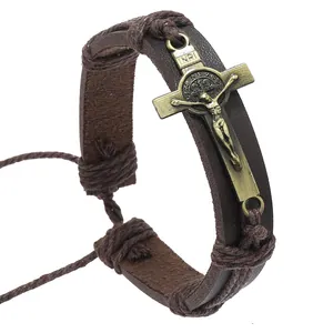 Detail of vintage brown leather bracelet featuring a brass crucifix with INRI engraving