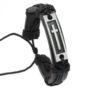 Detail of men's leather bracelet featuring a silver cross metal plate and woven rope