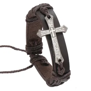 Close-up of vintage brown leather bracelet with silver cross and religious engraving