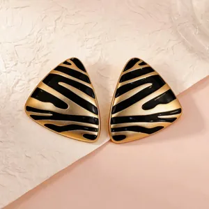 Retro gold and black zebra stripe enamel earrings in a vintage triangular geometric design