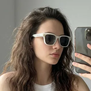 Close-up selfie view of white square sunglasses with dark lenses and silver metal accents