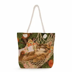 Detail view of canvas tote bag with cat and leaf print and white rope handles