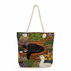 Detailed close-up of canvas tote bag with floral cat print and thick rope handles