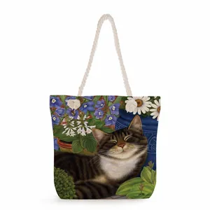 Close-up of canvas tote bag with floral cat print and thick rope handles detail