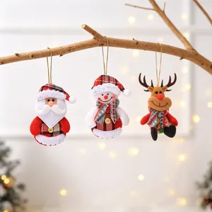 Three Christmas plush ornaments with Santa Snowman and Reindeer on a rustic tree branch