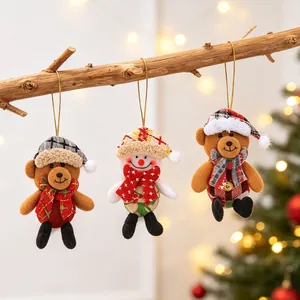 Three Christmas plush ornaments including bears and a snowman hanging on a branch
