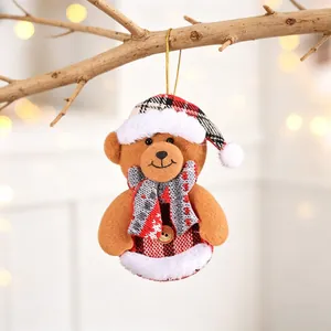 Detail of Christmas plush bear ornament with plaid hat and wood button on tree