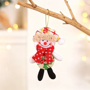 Close-up of a plush snowman ornament hanging on a wooden branch with festive bokeh lights