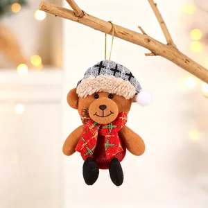 Detail of Christmas teddy bear ornament with grey plaid hat and red scarf on a tree
