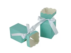 Close-up of light blue candy boxes with wave edges and white satin ribbon bows