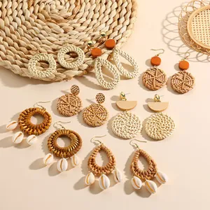 Flat lay of bohemian woven rattan earrings set with shells and natural textures
