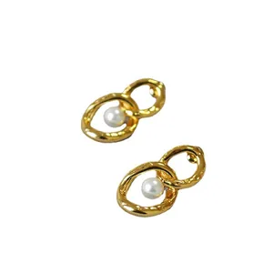Goldene Gliederketten-Ohrringe mit Perlen und Hammerschlag-Struktur auf Weiß