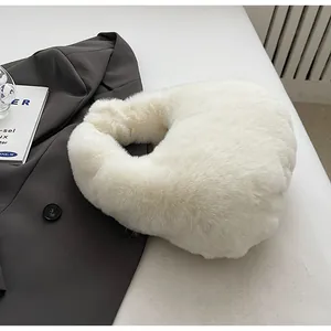 Detail of soft white faux fur hobo bag placed on a grey blazer for winter styling