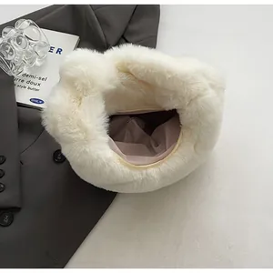 Close-up of white plush dumpling bag featuring a smooth zipper and light pink lining