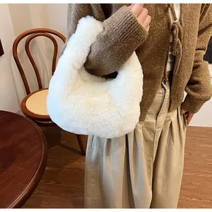 Detailed texture of a soft white faux fur handbag held against a brown cardigan