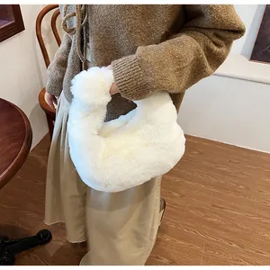 Close-up of plush white dumpling bag featuring soft faux fur and elegant crescent shape
