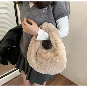 Detail of plush beige dumpling handbag showing soft faux fur texture and crescent shape