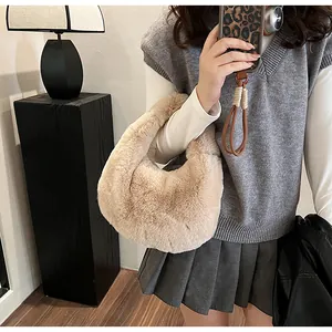 Detail showing plush cream dumpling handbag with soft faux fur texture and crescent design