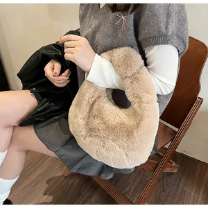 Detail of plush beige dumpling handbag showing soft faux fur texture and rounded profile