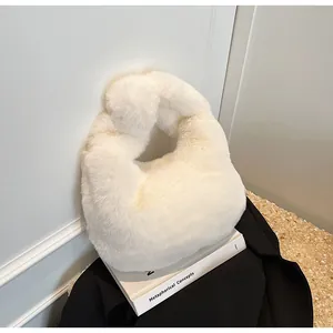 Detail of soft white faux fur handbag featuring a stylish knotted handle and plush texture